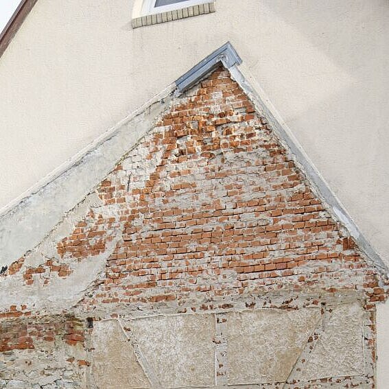 Eine Häuserwand. Zu sehen ist der Umriss eines Hauses, das vorher dort stand. 