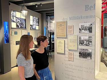 Zwei Besucherinnen betrachten Ausstellungsobjekte zum 17. Juni 1953.