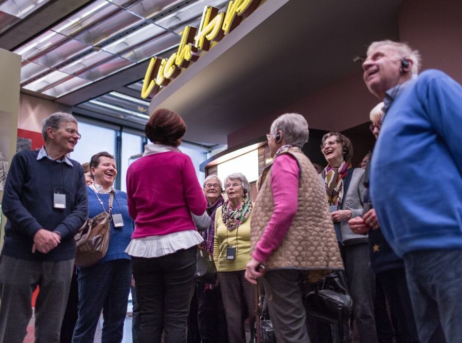 Eine Gruppe Senioren steht vor dem Kino in der Dauerausstellung in Bonn