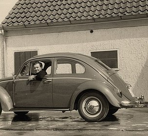 Lorenzo Annese schaut aus dem Fenster eines VW-Käfers, der vor einem Haus steht.