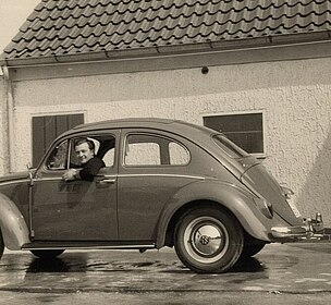 Lorenzo Annese schaut aus dem Fenster eines VW-Käfers, der vor einem Haus steht.