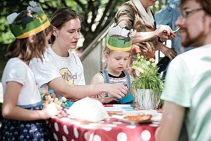 Familie bastelnd im Museumsgarten, (c) Jennifer Zumbusch, Stiftung Haus der Geschichte der Bundesrepublik Deutschland