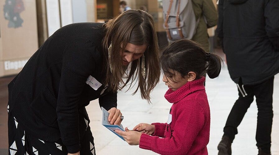 A guide is explaining something to a child in the exhibition.