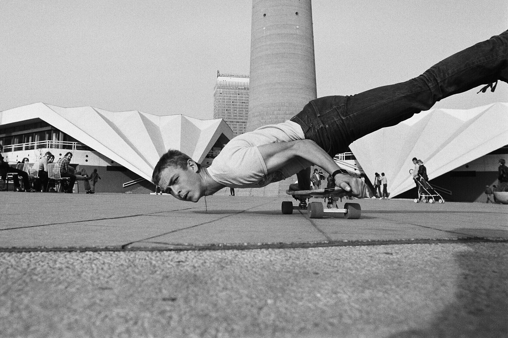Skater auf dem Alexanderplatz, Ost-Berlin 1982 Ein Skater fährt mit den Händen auf einem Skateboard abgestützt über den Alexanderplatz.