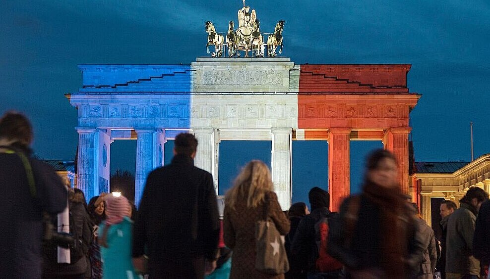 Fotografie von Pierre Adenis. Brandenburger Tor mit Tricolore-Beleuchtung. Rückblende 2015. Der deutsche Preis für politische Fotografie und Karikatur