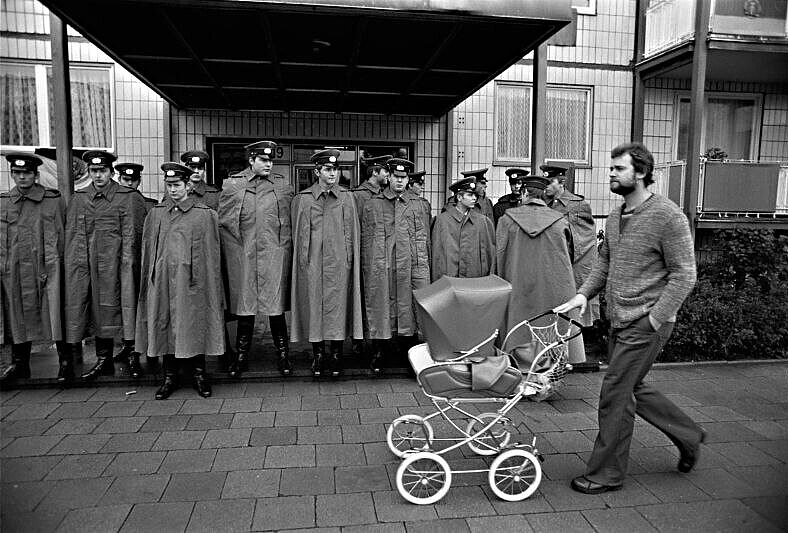 Photography: Man with pushchair in front of police officers on Karl-Marx-Allee in East Berlin, 1978