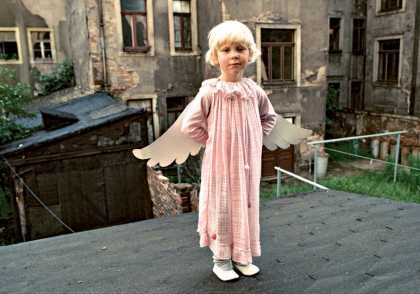 Ein Kind im Engelskostüm in einem Berliner Altbau-Hinterhof 1987