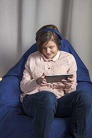 Mädchen nutzt Tablet und hört mit Kopfhörer, Foto: dzb lesen