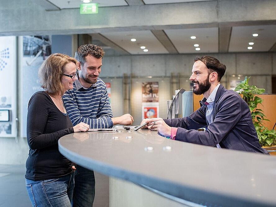 Zwei Besucher werden am Infoschalter im Foyer des Hauses der Geschichte Bonn beraten