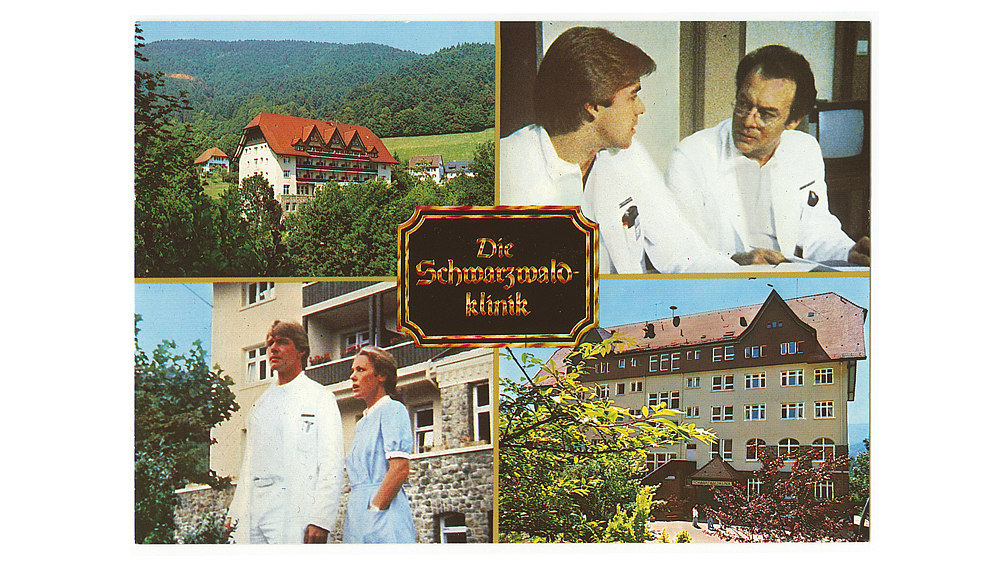 Die Ansichtskarte ist in verschiedene Farbfotos unterteilt, die die Schwarzwaldklinik und die Hauptdarsteller der Serie zeigen. 