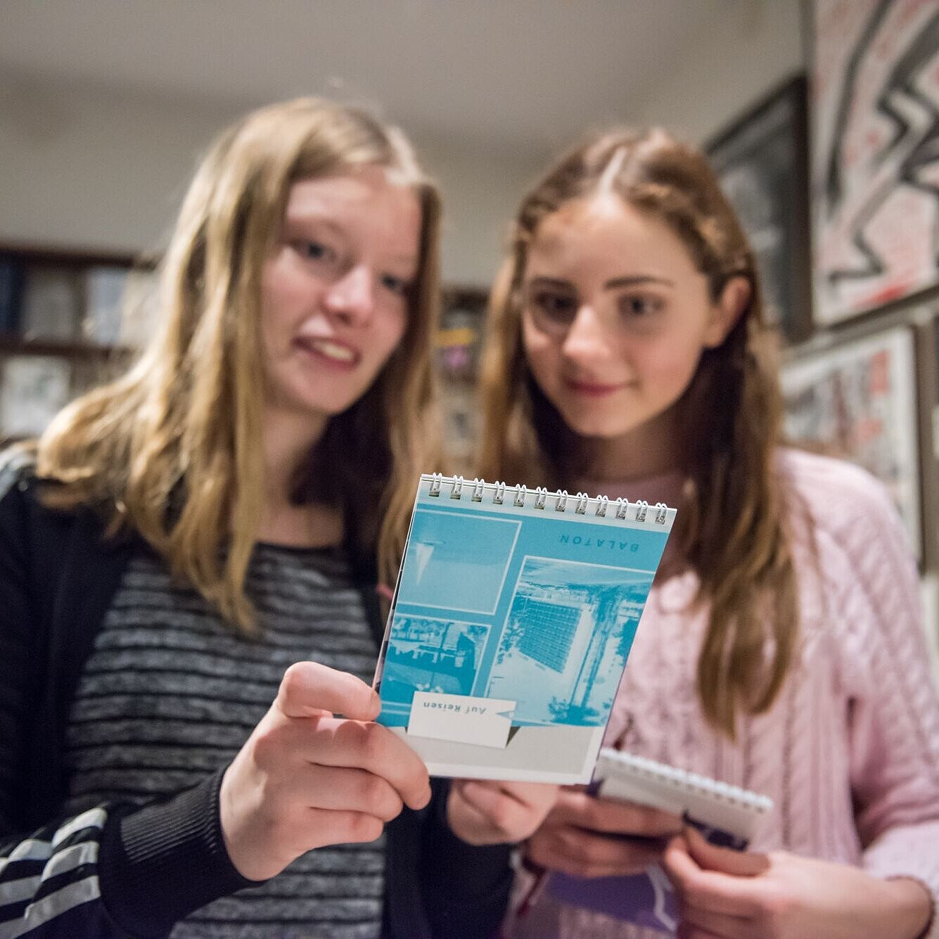 Zwei Mädchen betrachten ein Bildungsangebot