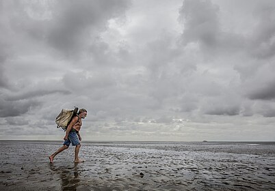 Foto "Knud Knudsen, Wattpostbote, trägt 2017 die Post von der Insel Pellworm zur Hallig Süderoog", (c) Hans-Jürgen Burkard