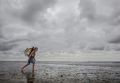 Foto "Knud Knudsen, Wattpostbote, trägt 2017 die Post von der Insel Pellworm zur Hallig Süderoog", (c)  Hans-Jürgen Burkard