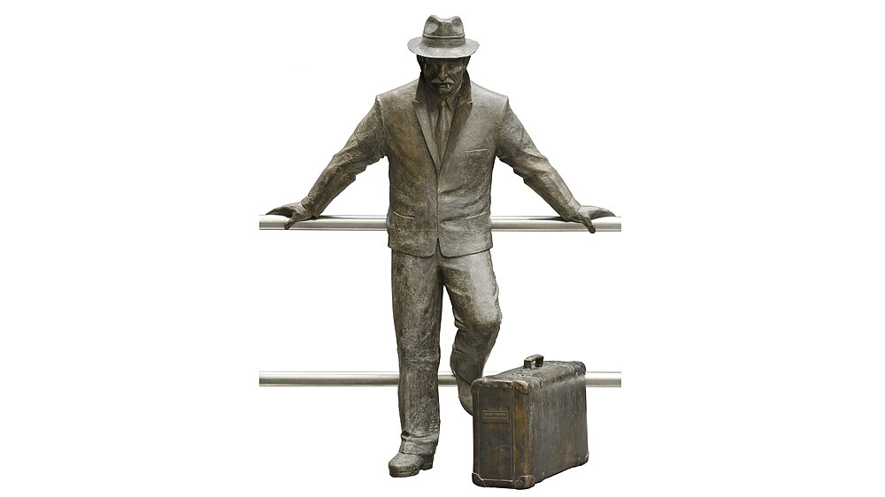 Bronze sculpture of a man with a suitcase