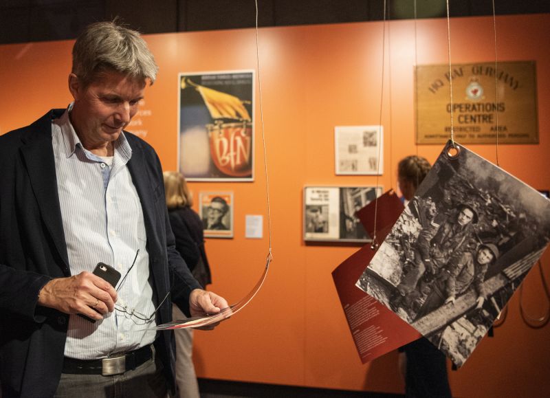 Ein Mann liest sich in der Ausstellung einen Text zu einem Foto durch.