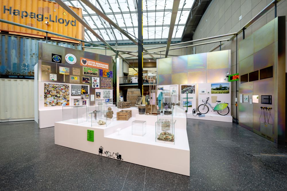 Im Vordergrund Objekte mit Schlammspuren, im Hintergrund Transparente von Klimademonstrationen