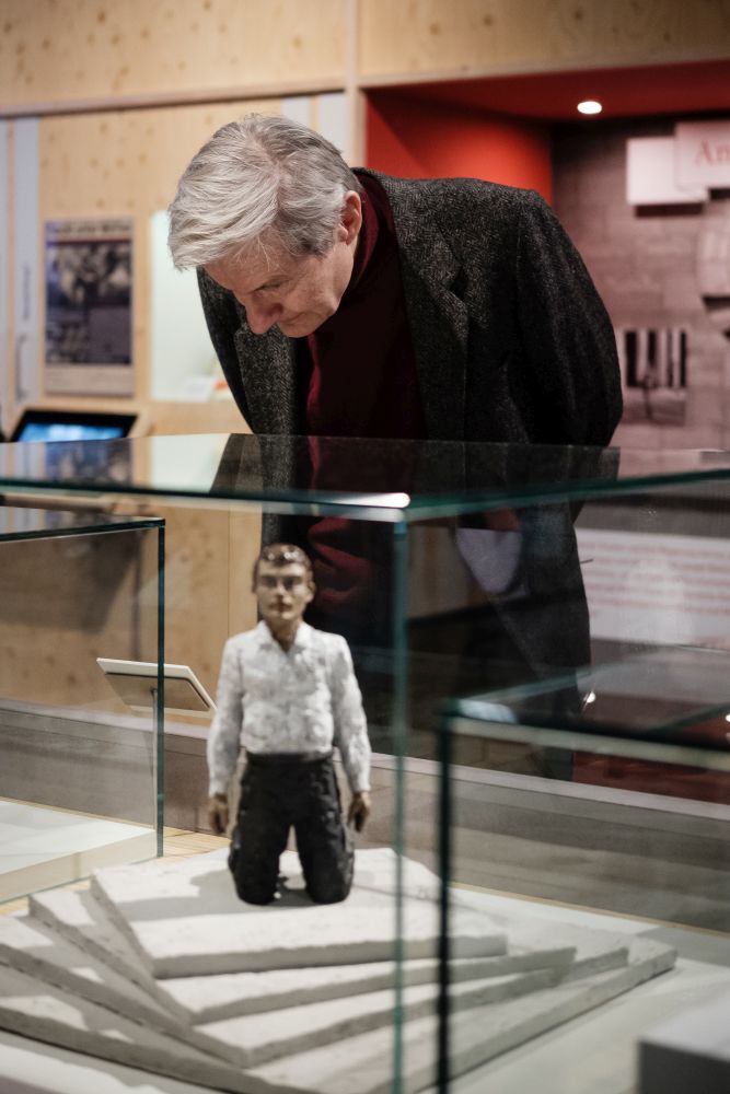 Man looks at a "Kniender Riesenmann", a draft for the "Monument to Freedom and Unity"