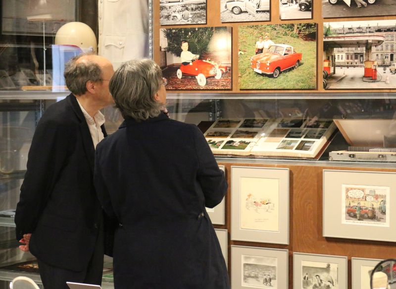 An elderly couple looking at old photos on a wall in the show room.