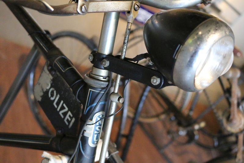 Detail photo of a dark blue men's bike with front light and the lettering police on the bumper.