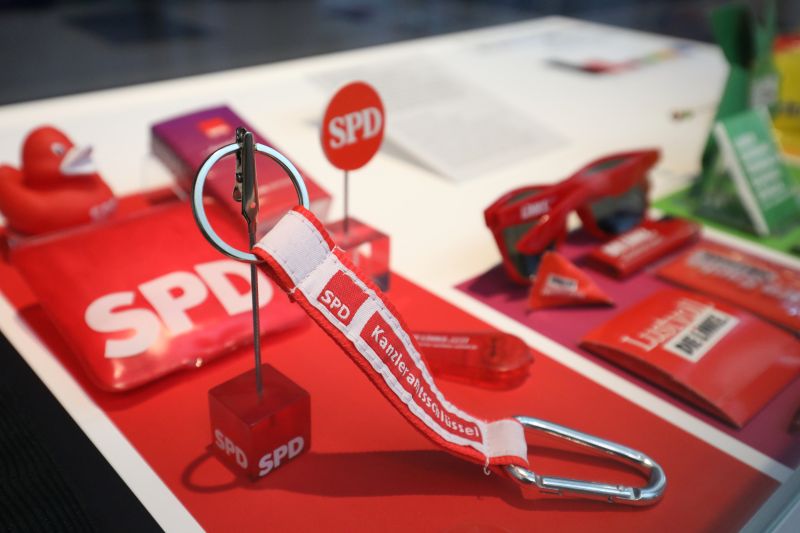 Ein Schlüsselanhänger, eine Sonnenbrille, eine Quietscheente und weitere Gegenstände mit den Logos von SPD und Die Linke.