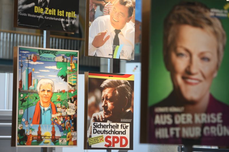 PersonalHans-Christian Ströbele, Hans Josef Strauß, Helmut Schmidt und Renate Künast werben auf Wahlplakaten für ihre Parteien.