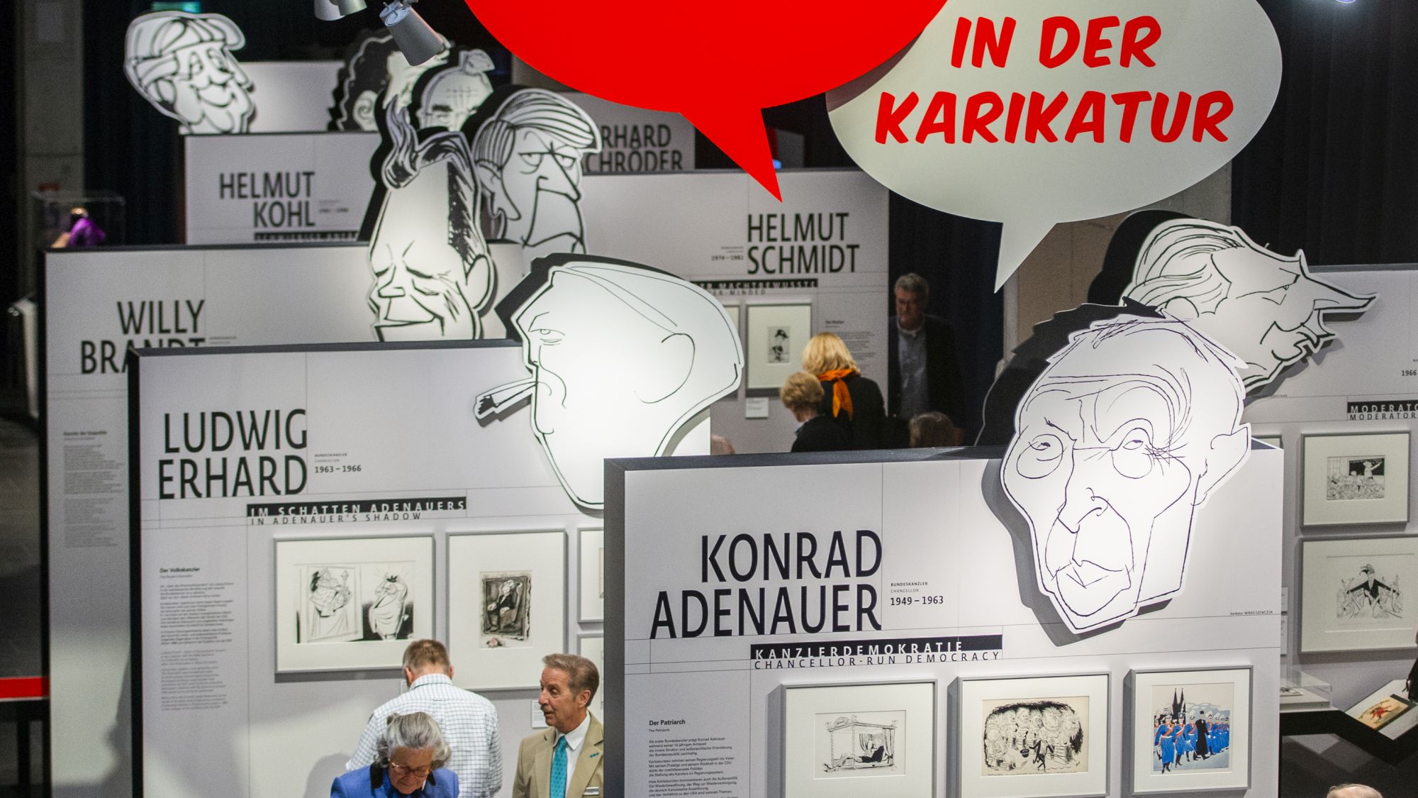 Vogelperspektive auf die Ausstellung mit großen Karikaturen der deutschen Bundeskanzler.