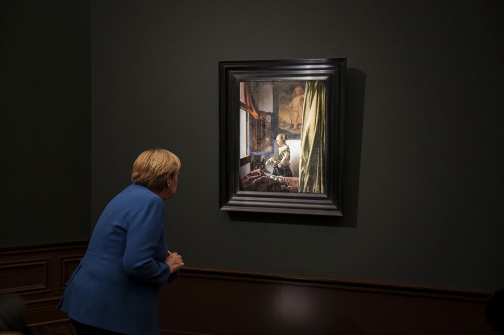 Angela Merkel betrachtet das Gemälde Briefleserin am offenen Fenster von Johannes Vermeer