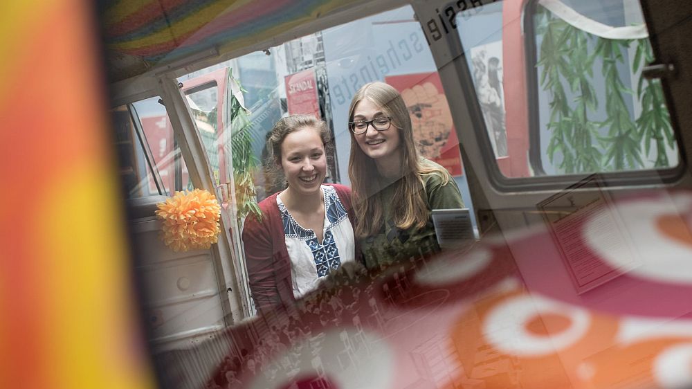 Zwei junge Mädchen stehen am VW Bulli in der Dauerausstellung im Haus der Geschichte in Bonn