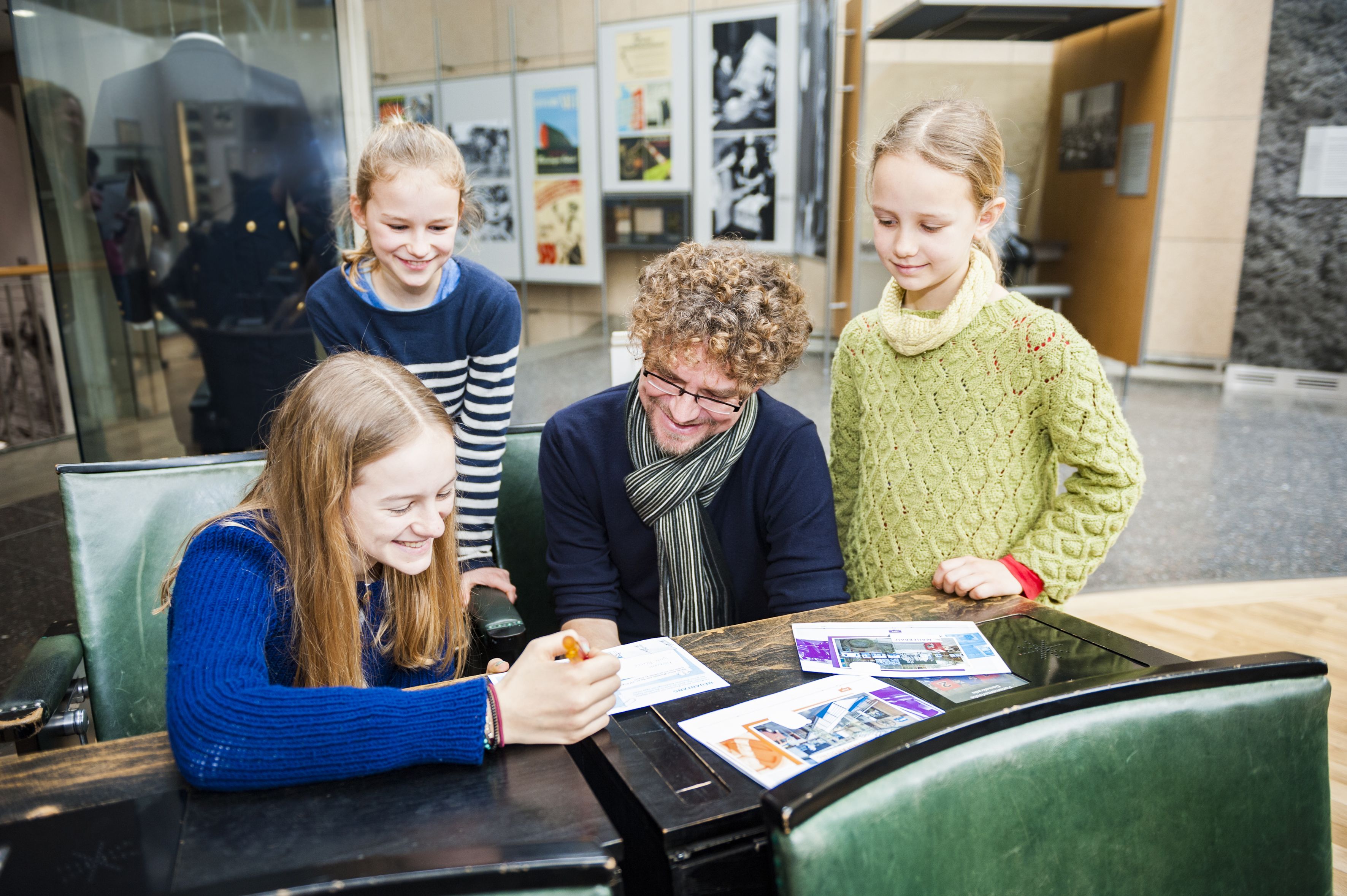 Familie im Bundestagsgestühl im Haus der Geschichte mit museumspädgagogischer Familientour