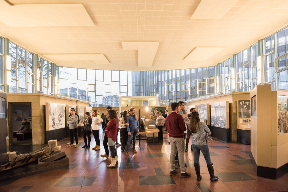 Blick von hinten über den ganzen Innenraum des Tränenpalastes und die Ausstellung mit vielen Besuchern