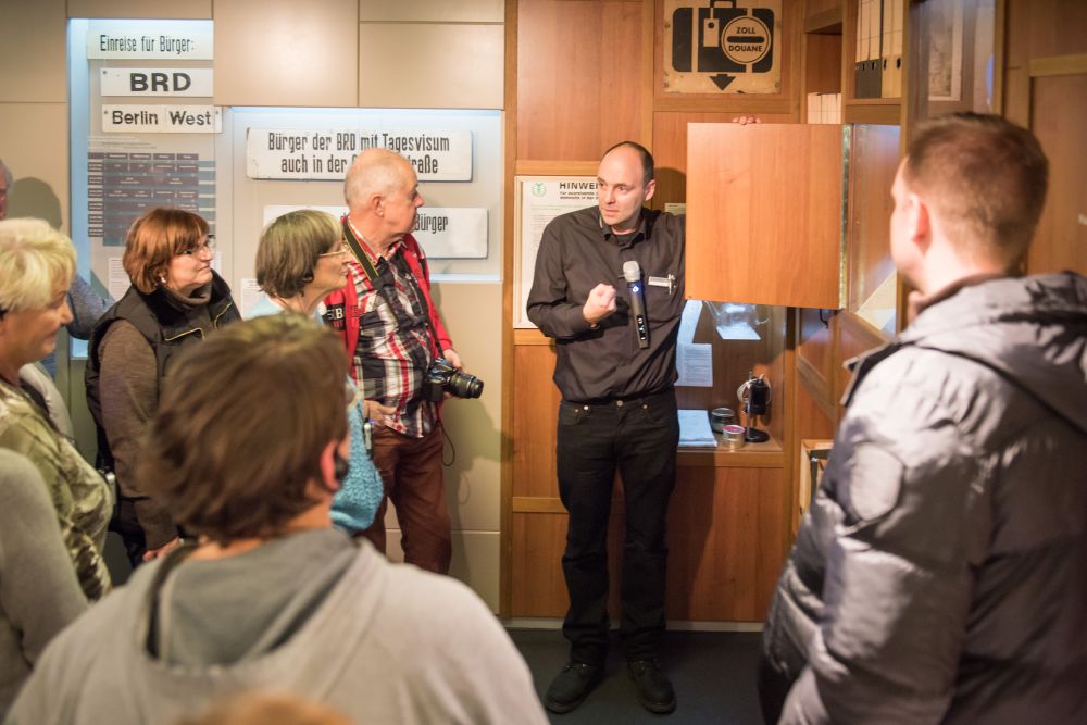 Ein Gruppenbegleiter spricht zu Besuchern im Tränenpalast