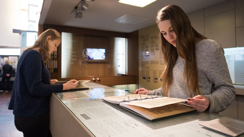 Zwei Frauen blättern in Ausstellungselementen im Tränenpalast