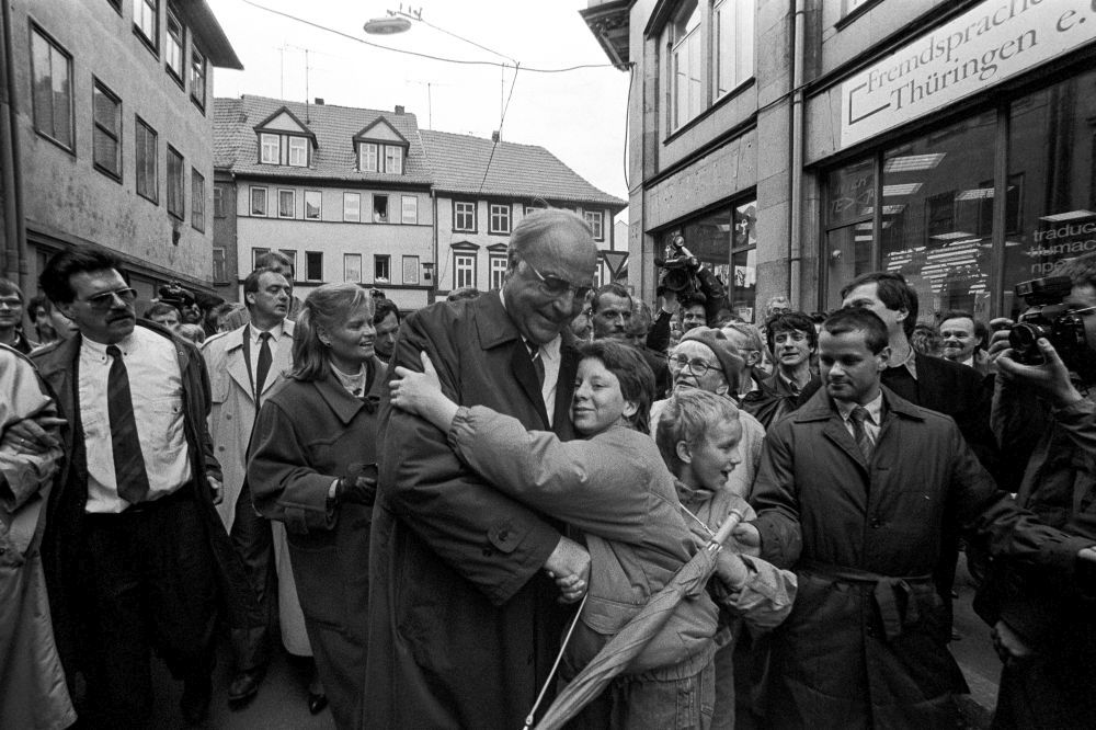 Erfurt, Bundeskanzler Helmut Kohl bei seinem ersten Besuch nach der Wiedervereinigung im März 1991. Kohl wird von Kind umarmt. 