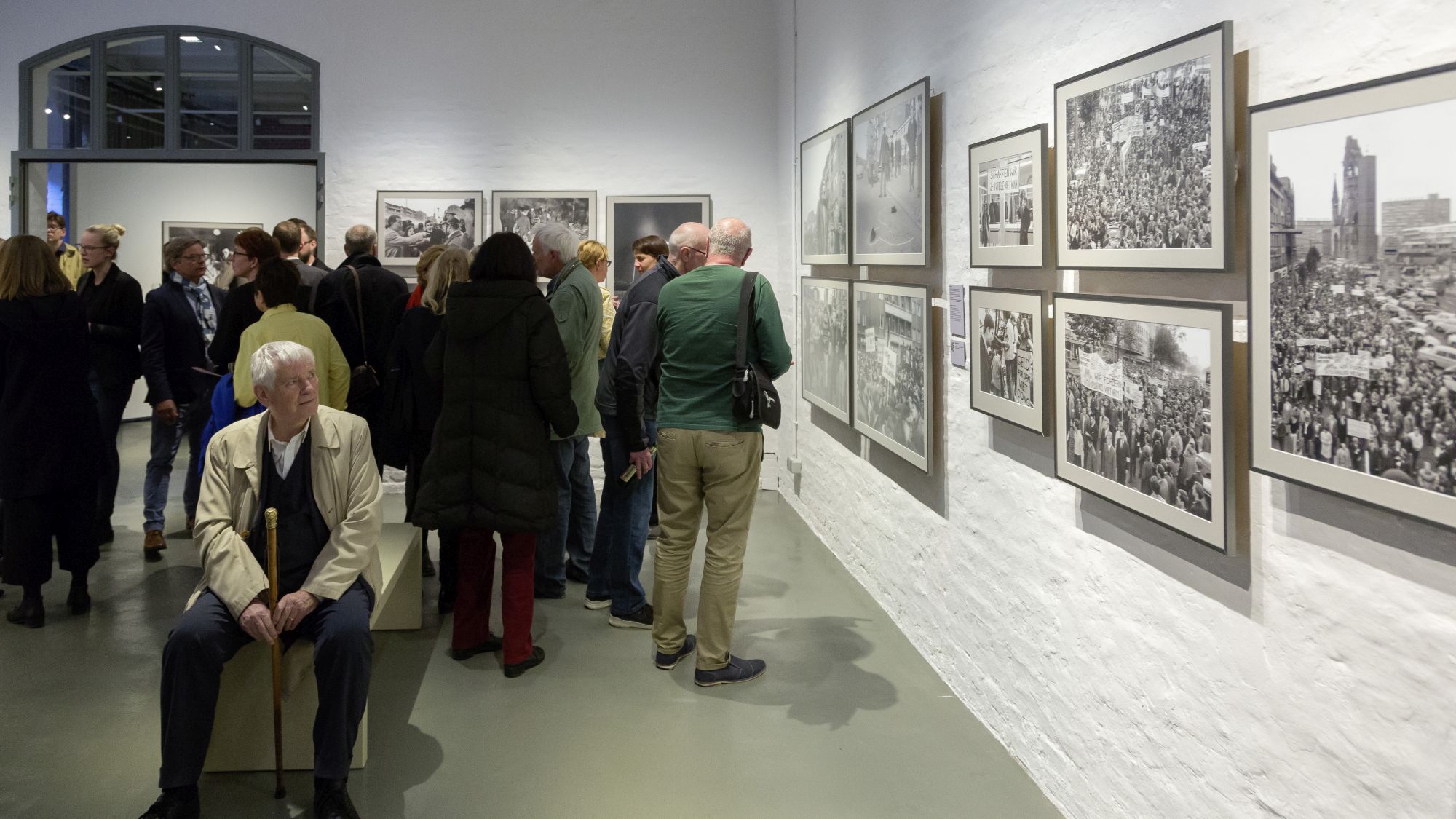 Otto Schily betrachtet Fotos in der Ausstellung