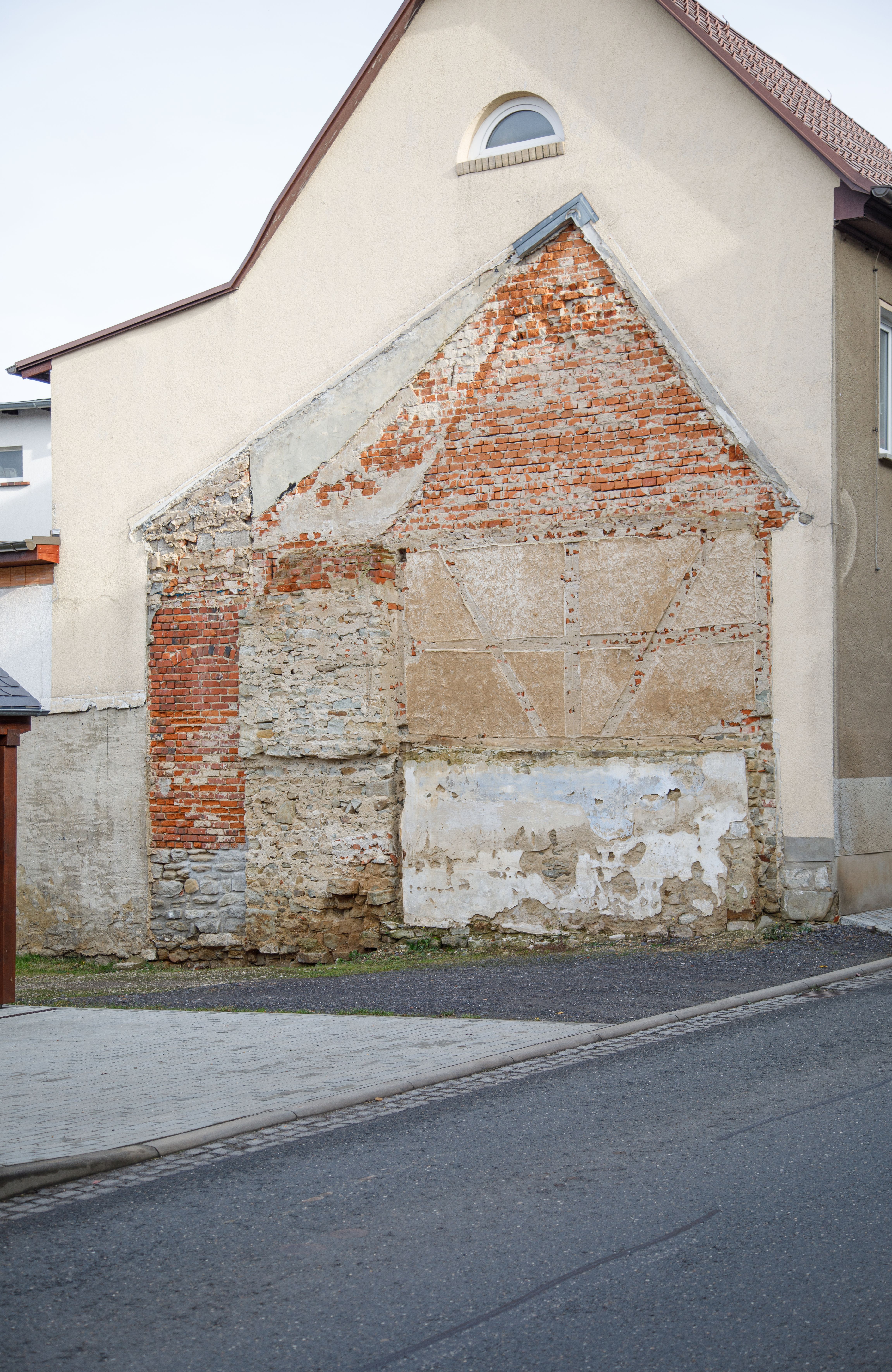 Eine Häuserwand. Zu sehen ist der Umriss eines Hauses, das vorher dort stand. 
