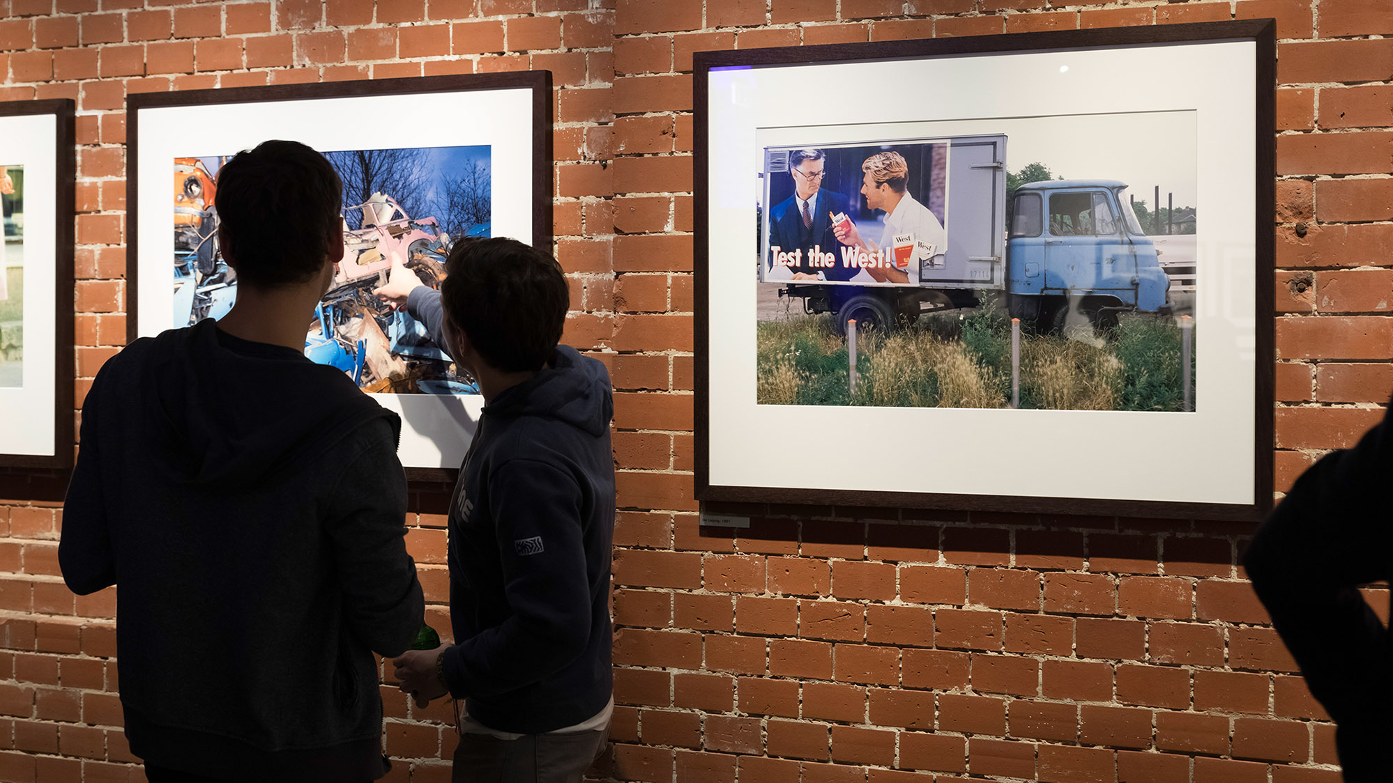 Besucher betrachten Fotografien von Daniel Biskup in der Ausstellung "Nach dem Mauerfall" 