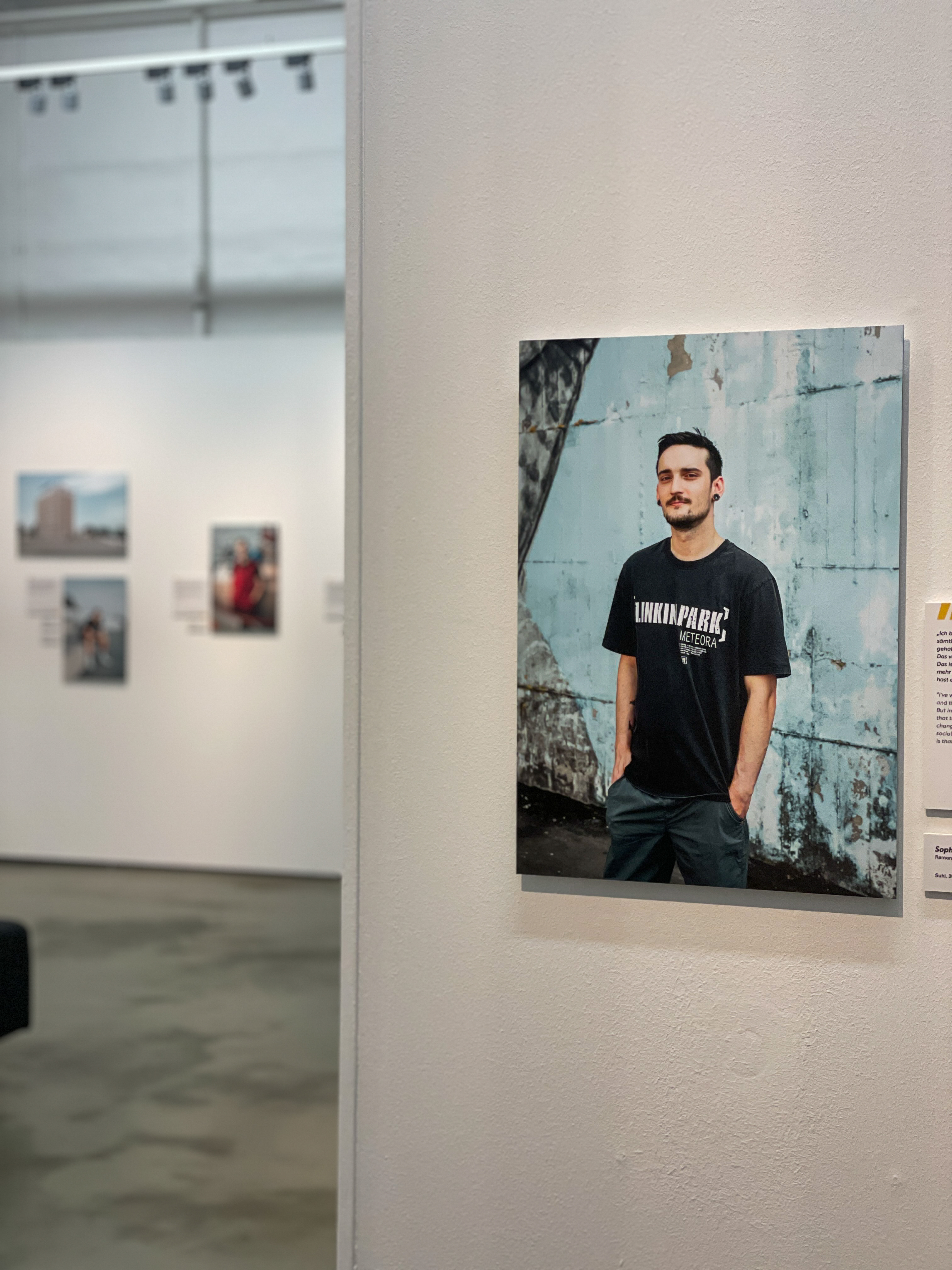 Fotoausstellung. Im Vordergrund ein Bild von einem jungen Mann. 