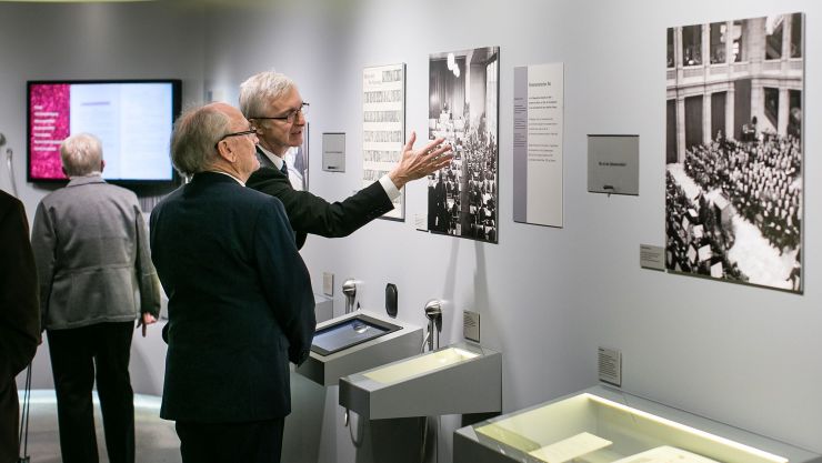Zwei Besucher vor historischen Fotos in Ausstellung