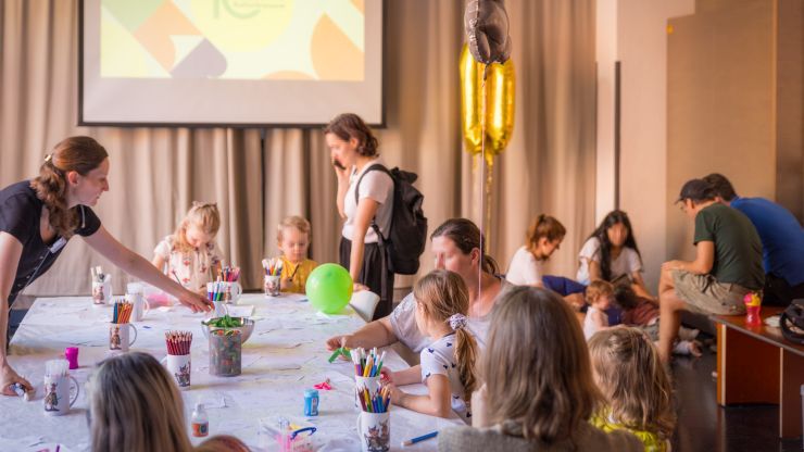 Kinder und Erwachsene an einem Tisch mit Bastelutensilien.