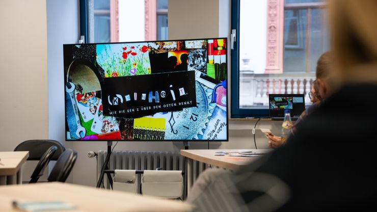 Foto eines Bildschirms mit einer bunten Grafik zum Film der Bildungsinitiative k_einheit