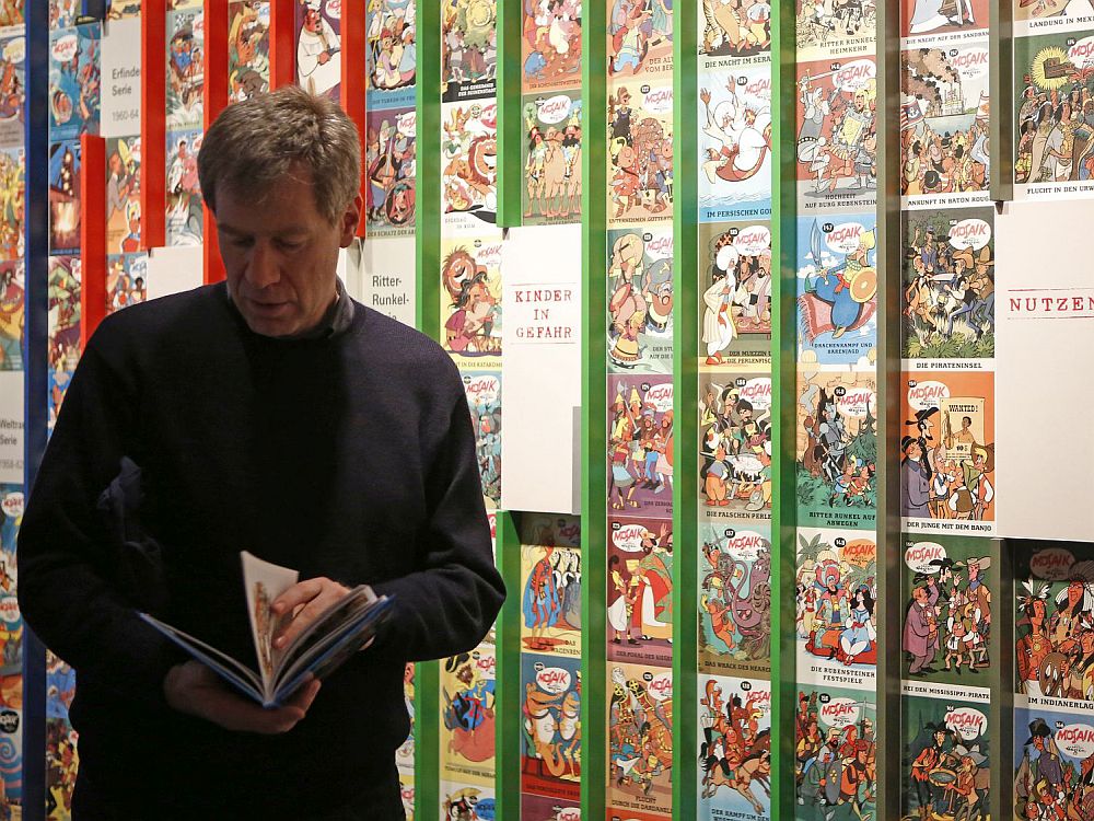 Mann mit Comic in der Ausstellung Mosaik im Zeitgeschichtlichen Forum Leipzig