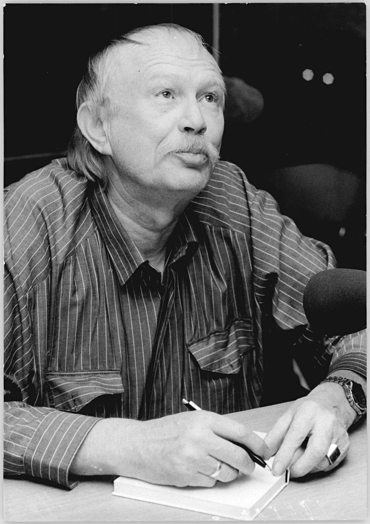 Porträtfoto des DDR-Schriftstellers Heinz Kahlau beim Signieren eines Buches, 1990.