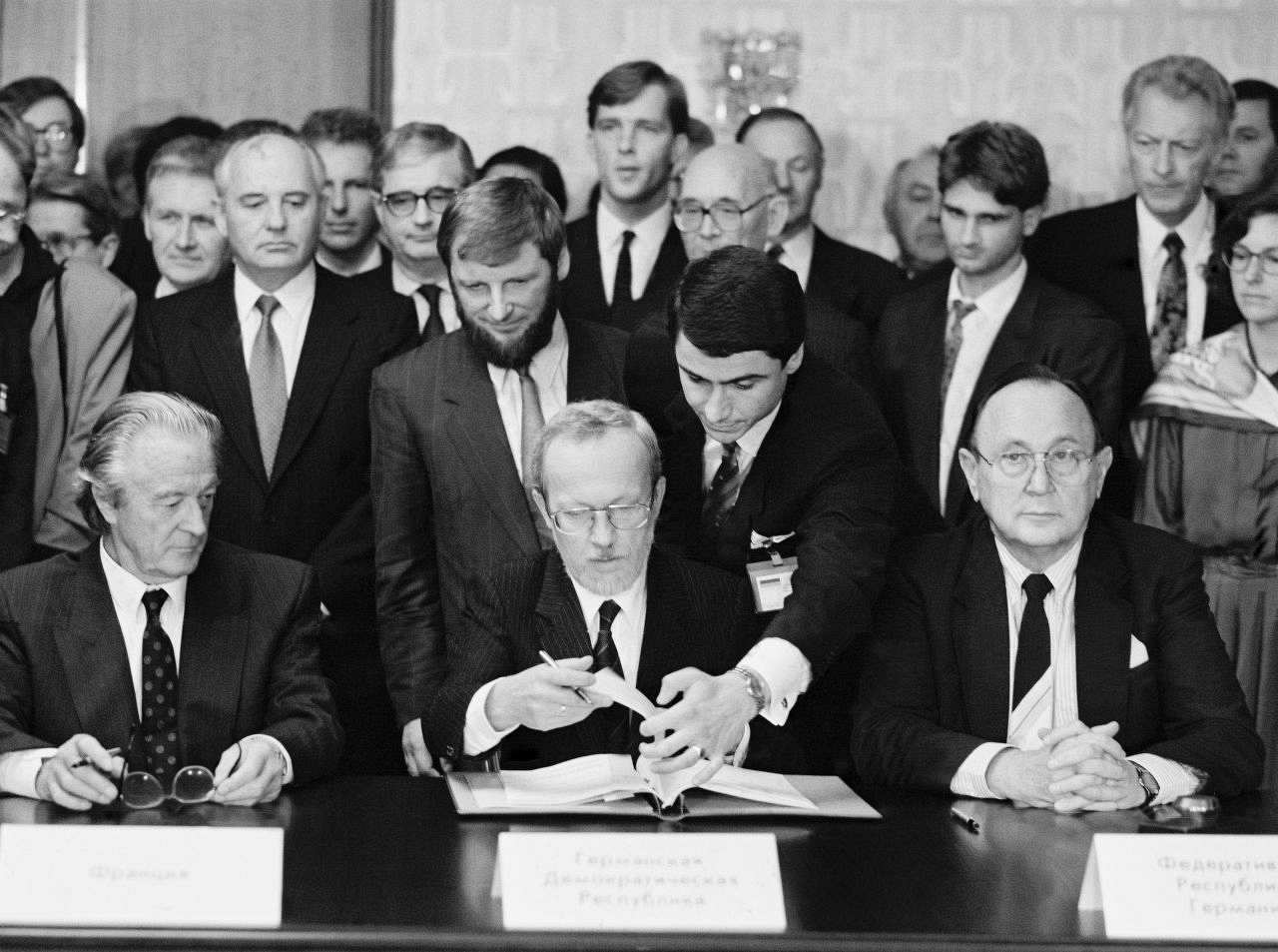 schwarzweiße Fotografie; Unterzeichnung des Zwei-Plus-Vier-Vertrages in Moskau im Hotel Oktjabrskaja.
von links nach rechts: Roland Dumas (Frankreich), dahinter stehend Michail Gorbatschow (UdSSR), Lothar de Maizière (DDR), Hans-Dietrich Genscher (Bundesrepublik Deutschland).