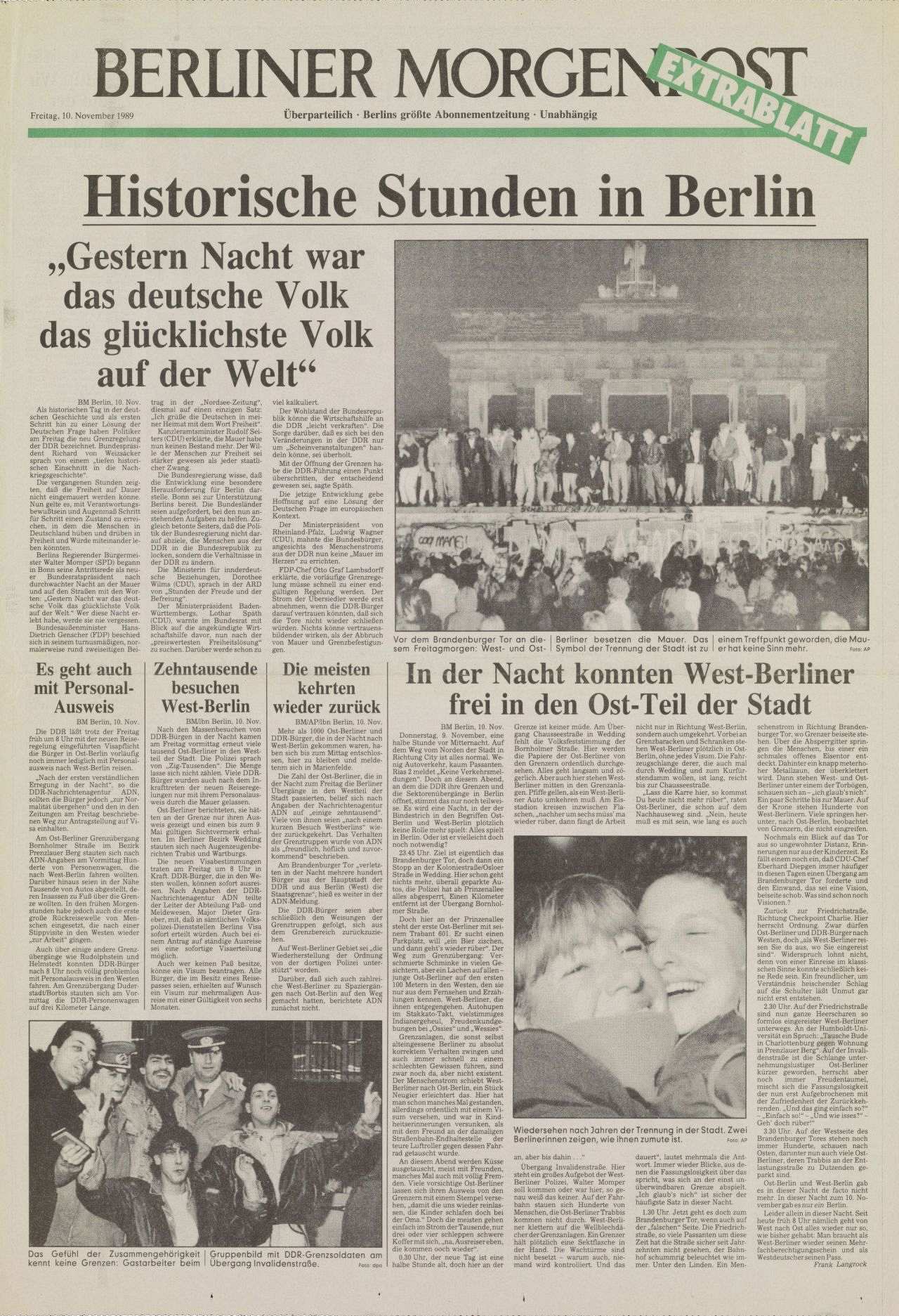 Titelseite der Berliner Morgenpost vom 10. November 1989. Schlagzeile: Historische Stunden in Berlin. Zitat: Gestern Nacht war das deutsche Volk das glücklichste auf der Welt. Großes schwarzweißes Foto einer großen Menschenmenge auf der berliner Mauer vor dem Brandenburger Tor. Weitere Artikel und Fotografien zum Mauerfall. Auf der zweiten Seite Nahaufnahme von Personen, die gerade über die Mauer klettern. Auf der Mauer reichen andere Menschen die Hände, um die Kletterer hochzuziehen. Ein zweites Foto zeigt einen Mann in einem Trabant, der bei offener Schranke über die Grenze fährt. Rechts und links stehen Menschen, die ihn beklatschen.