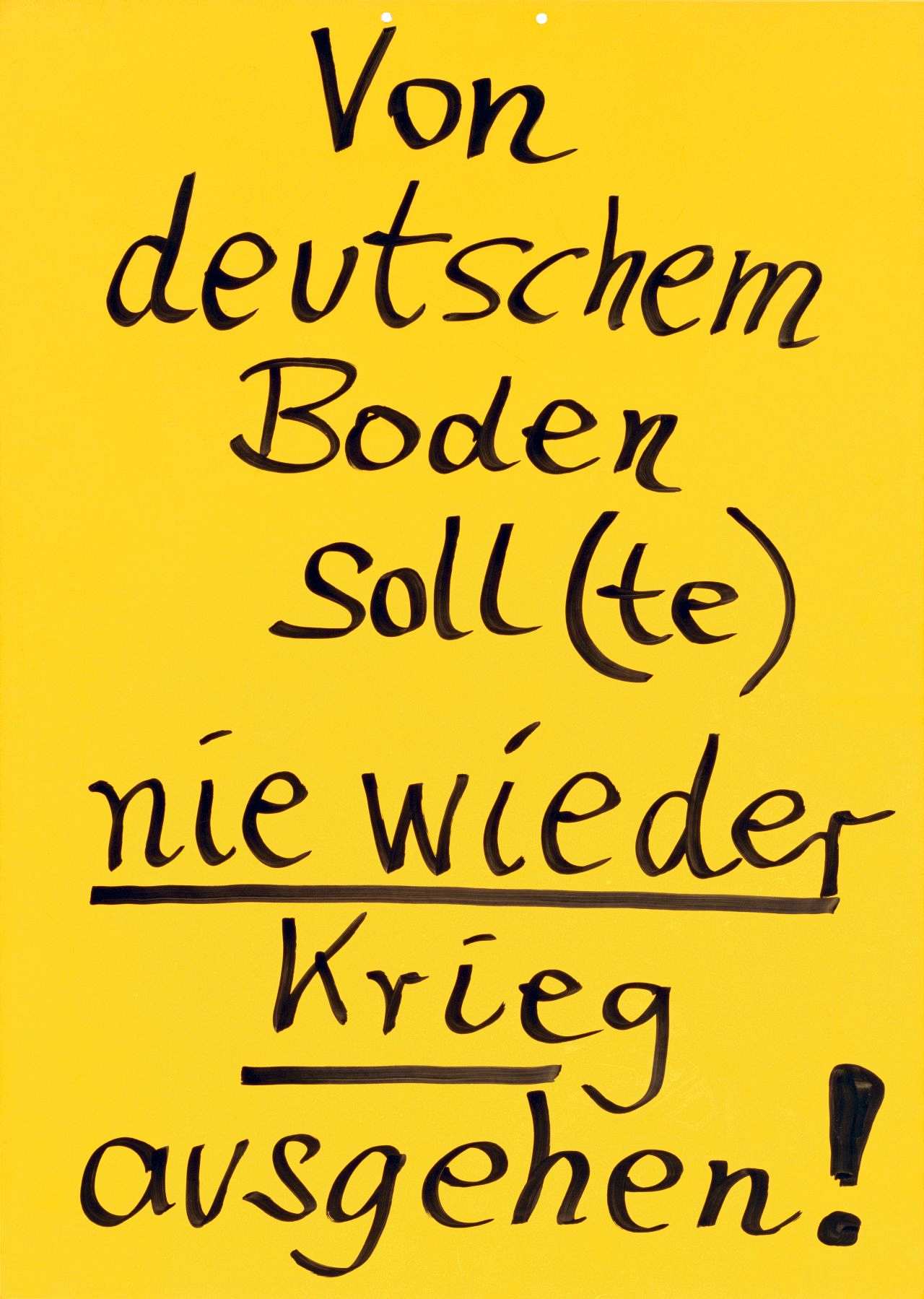 Gelbes Schild mit schwarzem Text, handgeschrieben: Von deutschem Boden soll(te) nie wieder Krieg ausgehen! Die Worte - nie wieder Krieg - sind zusätzlich unterstrichen.