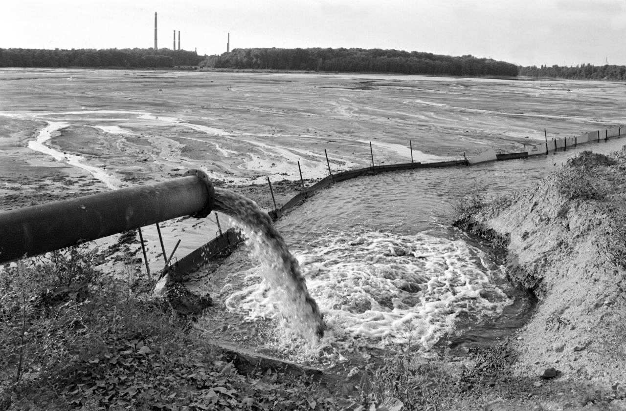 Das schwarz/weiße Foto zeigt die Einleitung von Abwässern bei Bitterfeld.