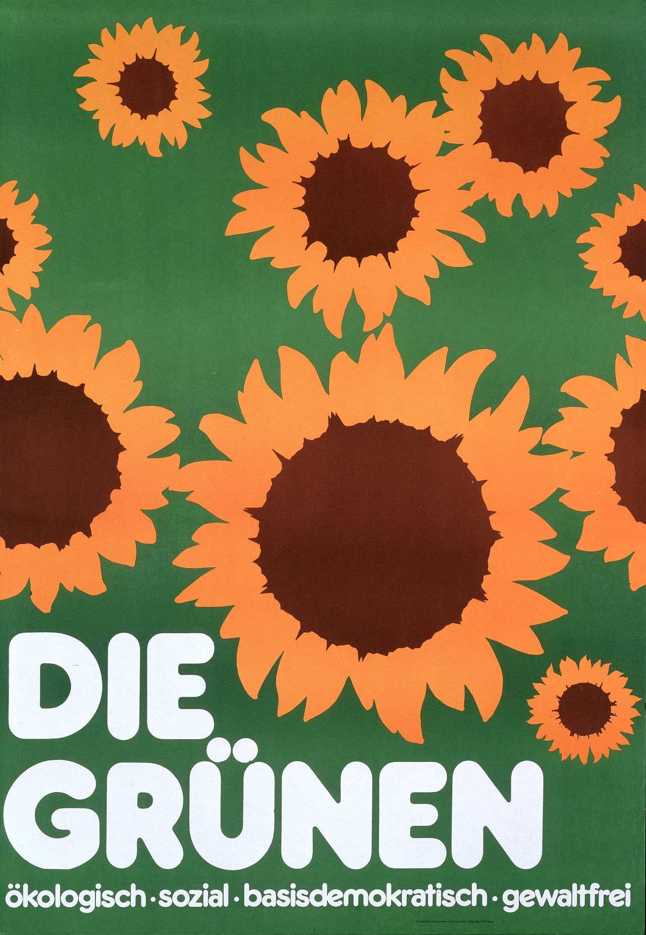 Grüngrundiges Plakat, verschieden große Sonnenblumenblüten (gelb, braun), unten mehrzeiliger Text (weiß): DIE / GRÜNEN / ökologisch, sozial, basisdemokratisch, gewaltfrei.