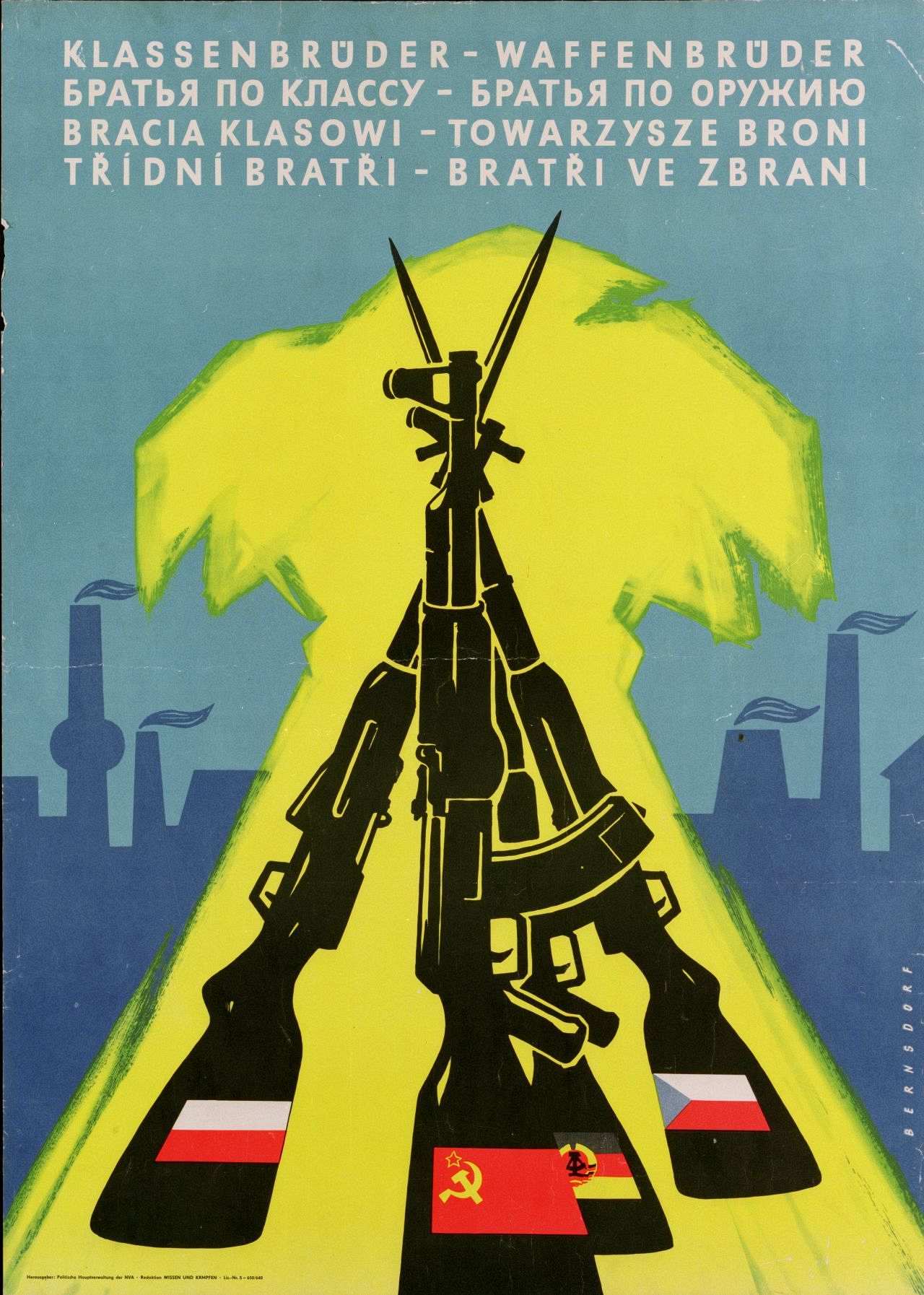 Blaues Plakat mit dunkelblauen Silhouetten von Industrieanlagen im unteren Teil. Im Vordergrund schwarze Darstellung einer Gewehrpyramide aus zwei Kalaschnikow-Sturmgewehren und zwei Selbstladekarabinern mit Bajonetten. Auf den Gewehrkolben je eine Fahne eines Warschauer Pakt-Staates: Polen, UdSSR, DDR und CSSR. Die Gewehrpyramide steht vor einer stilisierten gelben Getreidegarbe. Oben weißer Schrift: Klassenbrüder - Waffenbrüder. Der Spruch wird darunter in kyrillischer, polnischer und tschechischer Schrift wiederholt. Rechts unten am Rand: Bernsdorf. Links unten Schriftzug: Herausgeber: Politische Hauptverwaltung der NVA / Redaktion Wissen und Kämpfen / Liz.-Nr.5 - 650/640. Plakat auf Stoff aufgezogen.