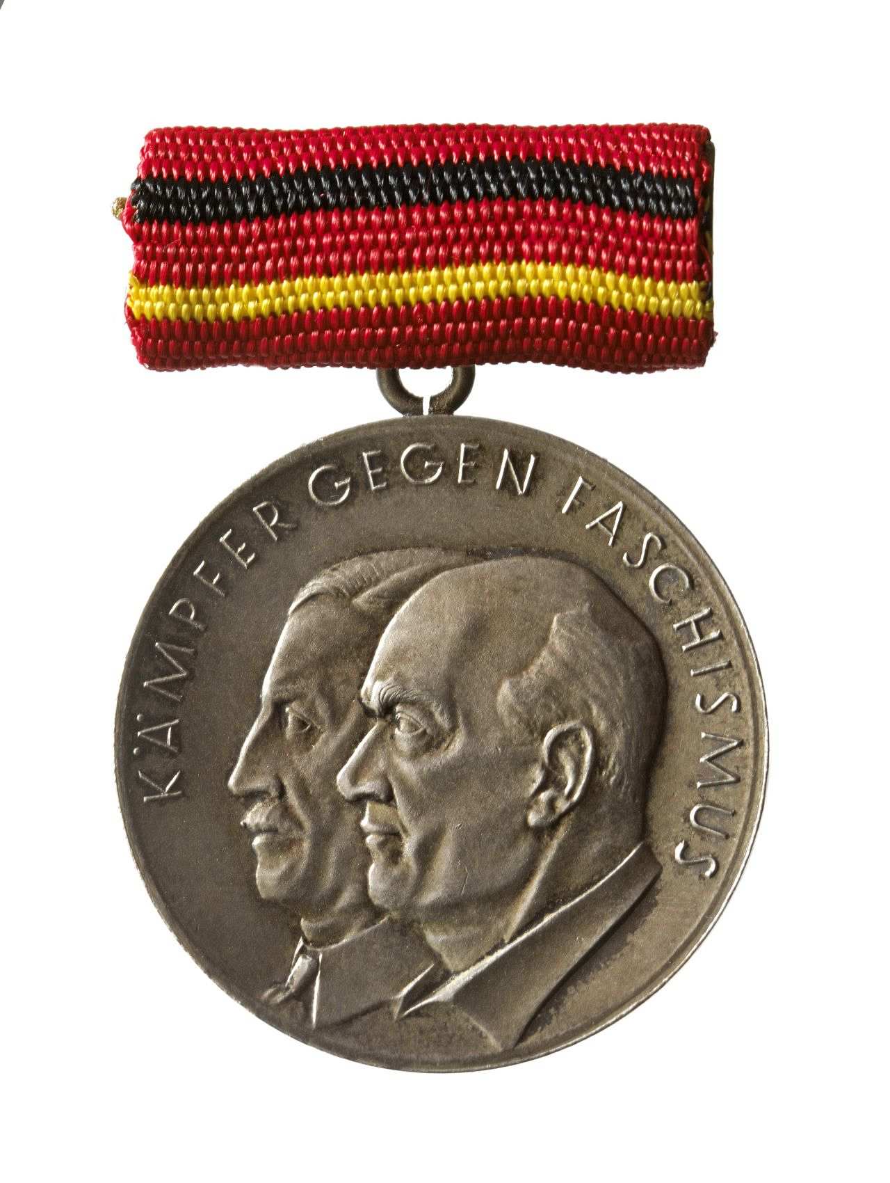 Silberfarbener Medaille; Vorderseite: Kopfbilder von Ernst Thälmann und Rudolf Breitscheid im Profil, erhabene Umschrift: 'Kämpfer gegen Faschismus'; Rückseite: Abbildung des Staatssymbols der DDR (Hammer und Zirkel), erhabene Umschrift: 'Vorwärts und nicht vergessen 1933-1945'. 
Medaille mit rechteckiger Tragespange, mit rotem Band bezogen, das in der Mitte mit schwarzrotgoldenen Querstreifen durchzogen ist.