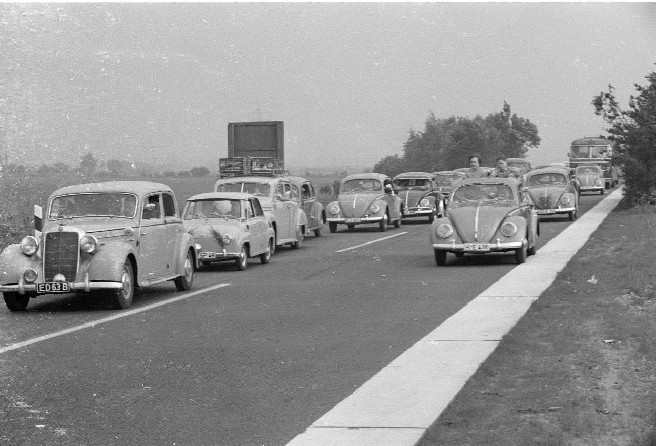 Schwarz-weiß-Fotografie des Verkehrs auf der Autobahn 1959: VW-Käfer, Mercedes und Gogo-Mobil.